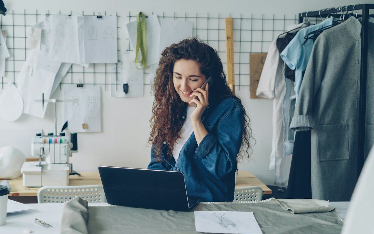 Craftswoman on the phone in front of her computer in her workshop