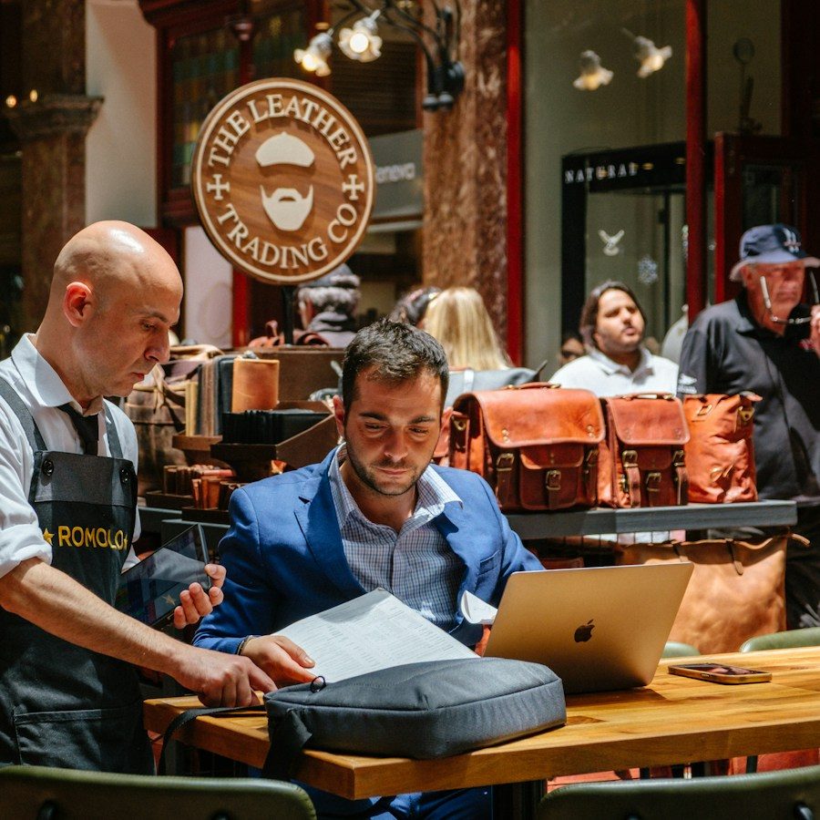 Shop owner following up on a customer file on a computer