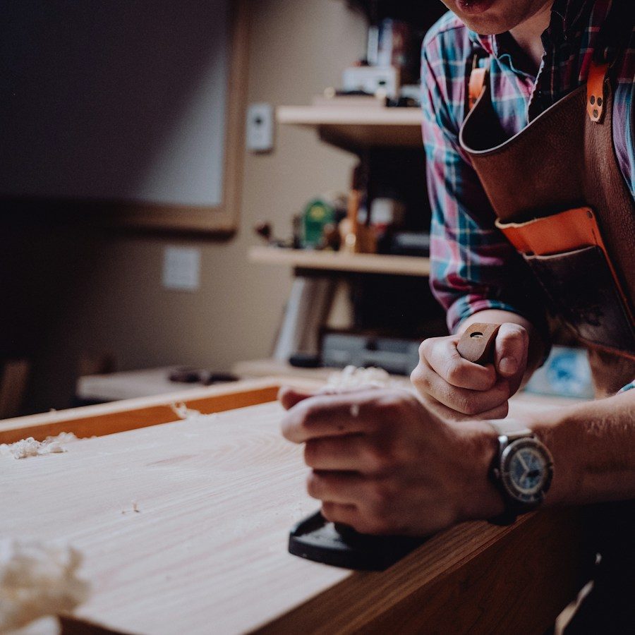 Craftsman planing a board in his workshop