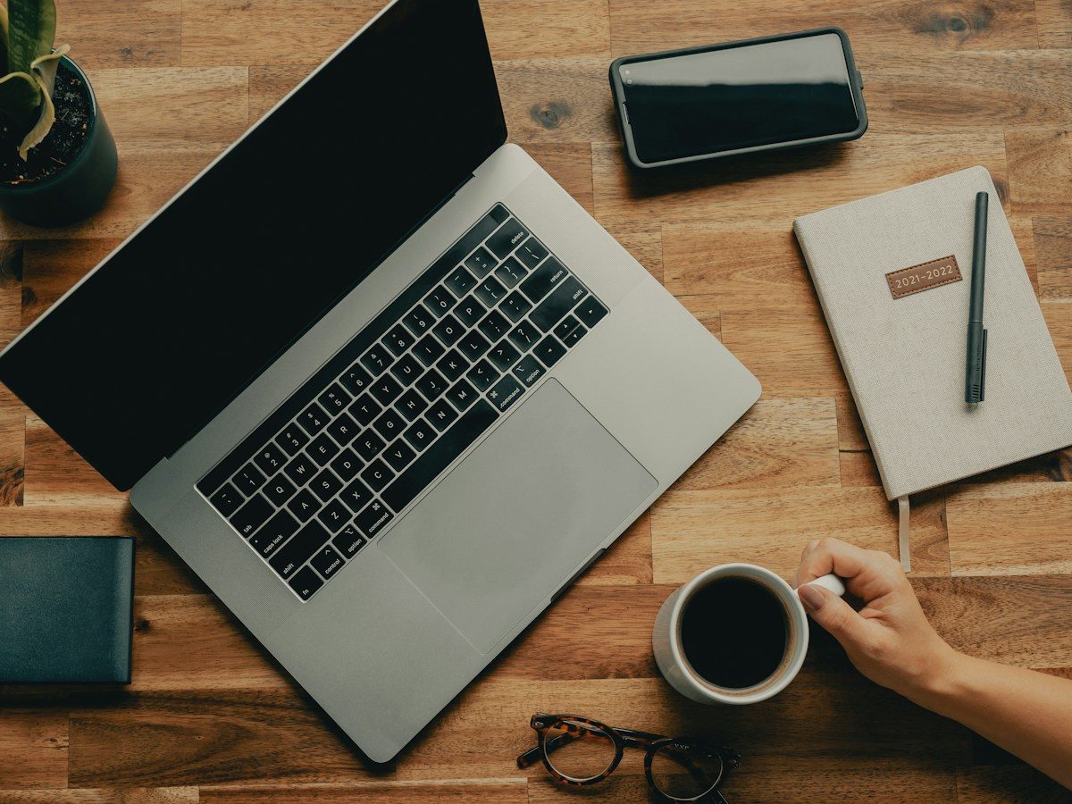 Laptop, notebook and coffee on a desk
