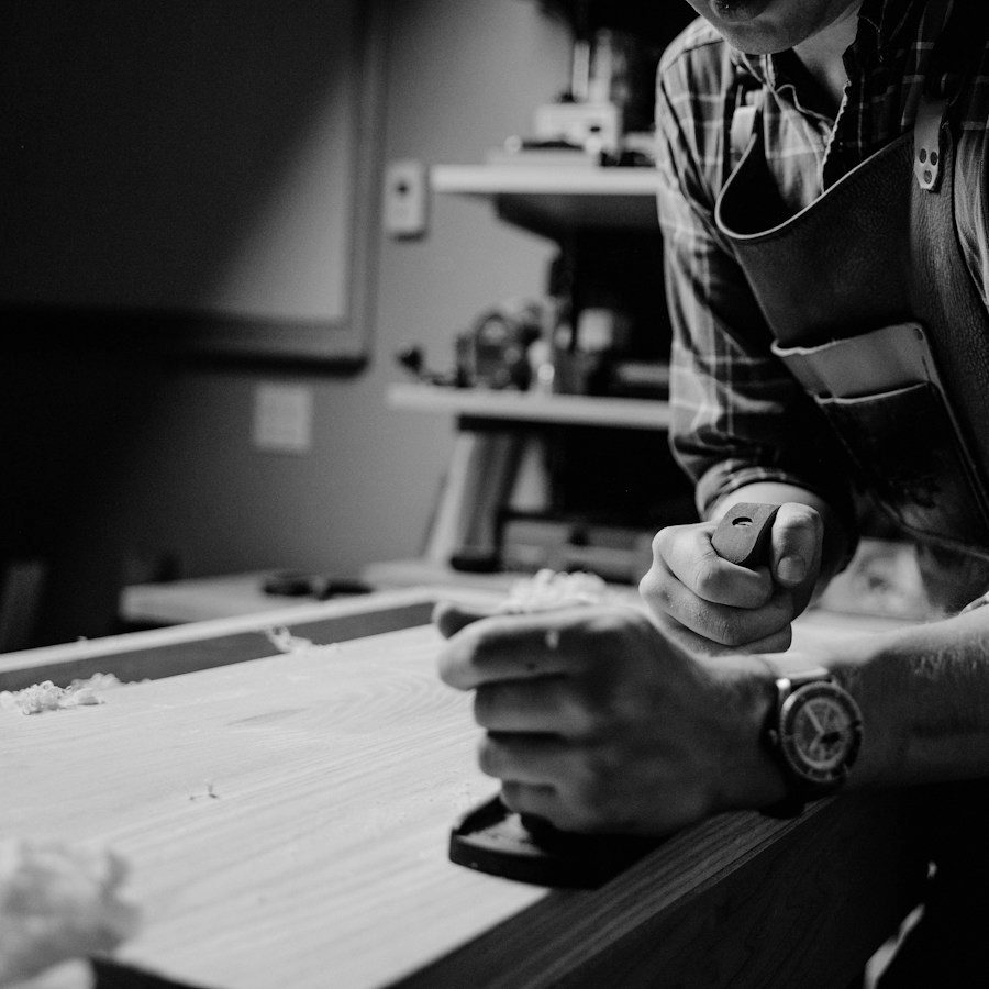 Craftsman planing a board in his workshop