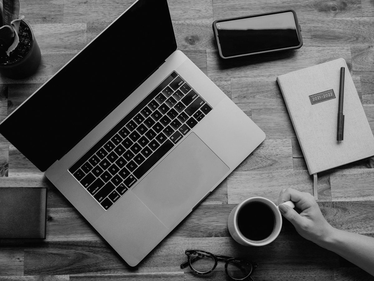 Laptop, notebook and coffee on a desk